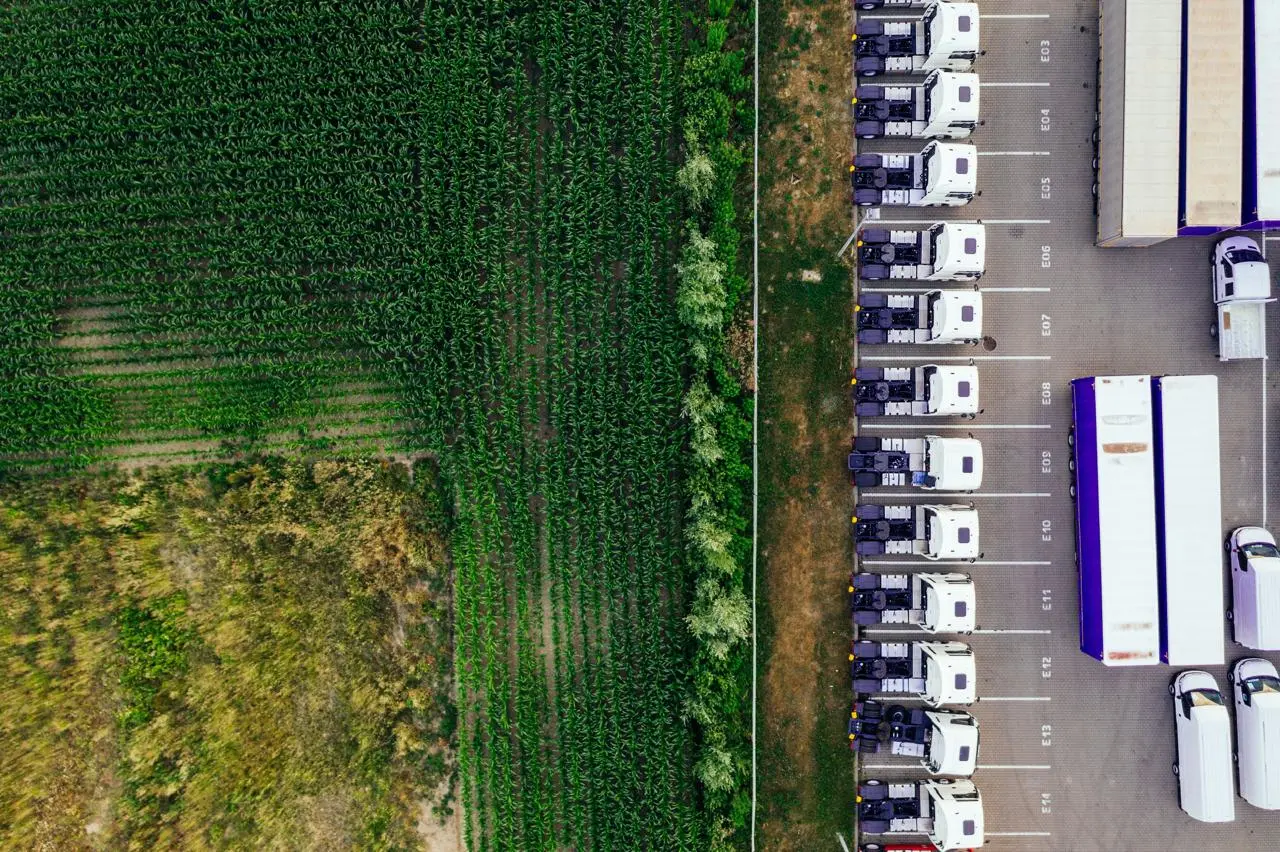 Flotte de camions circulant au cœur d'une zone agricole.